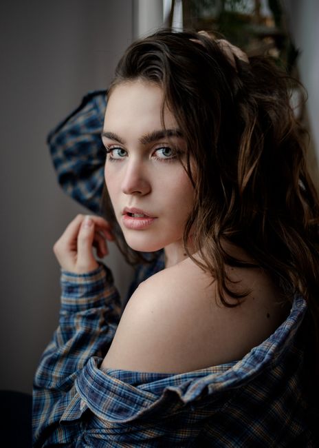 Stylish portrait of a woman with hand in hair, captured in a Des Moines, Iowa studio setting.