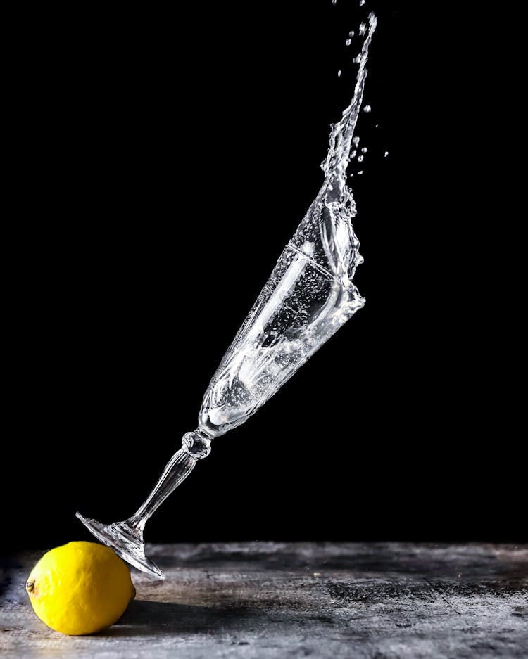 Falling Glass Of Water And Lemon And Black Back