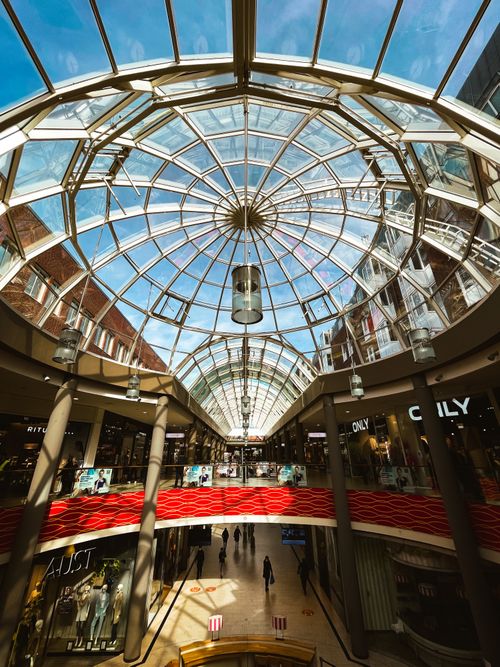 Free Spacious shopping mall interior with a stunning glass dome roof. Stock Photo