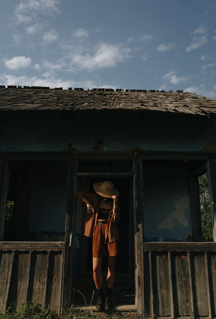 Unrecognizable Woman Leaving Old Timber Hut