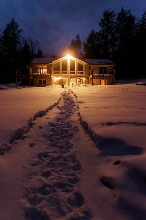 Wooden House on Snow Covered Ground during Night Time