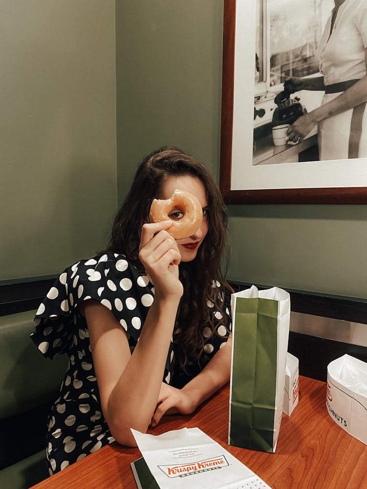 Girl Eating And Looking Through Donut