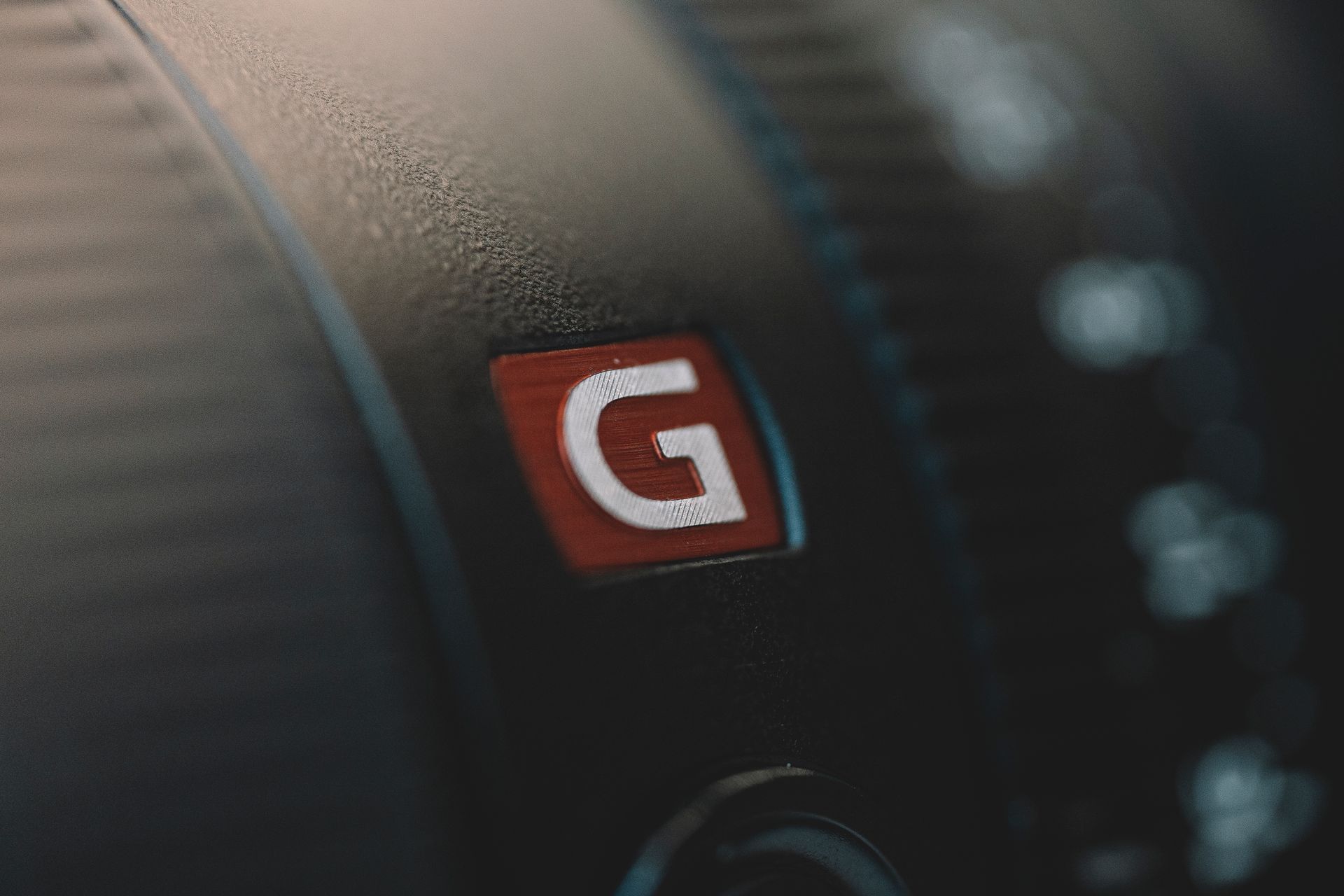 Macro shot of a camera lens showing a prominent 'G' logo on its surface.