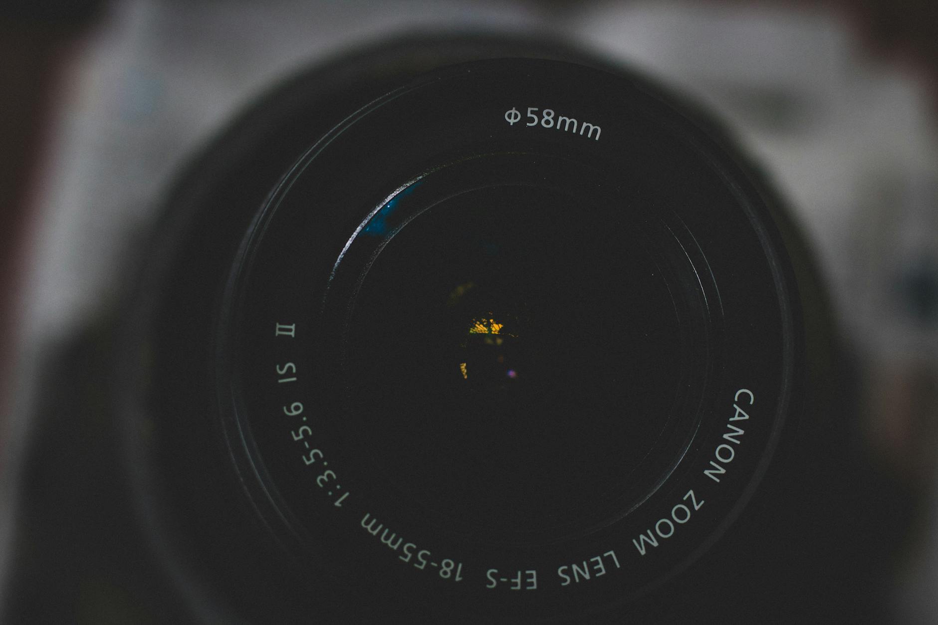 Detailed close-up of a Canon zoom lens highlighting aperture and focus.