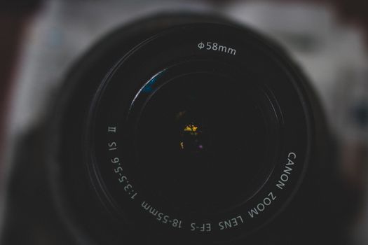 Detailed close-up of a Canon zoom lens highlighting aperture and focus.