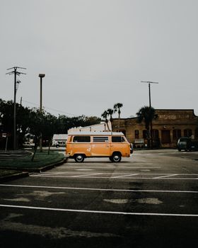 A vintage yellow van parked in an empty lot, capturing a nostalgic travel vibe.