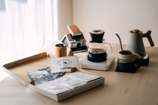 A serene coffee brewing scene featuring accessories and a pour-over setup on a wooden table, ideal for coffee enthusiasts.