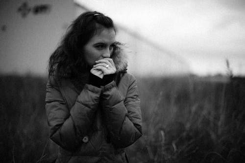 Grayscale Photo of a Woman in a Puffer Jacket