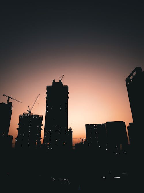 Silhouette of Buildings During Orange Sky