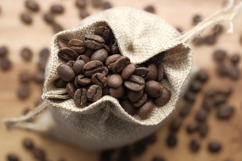 Free A detailed close-up of roasted coffee beans in a burlap bag, perfect for coffee enthusiasts. Stock Photo