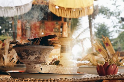 Balinese offering ritual with incense smoke in Marga, Bali, showcasing cultural decorations and atmosphere.