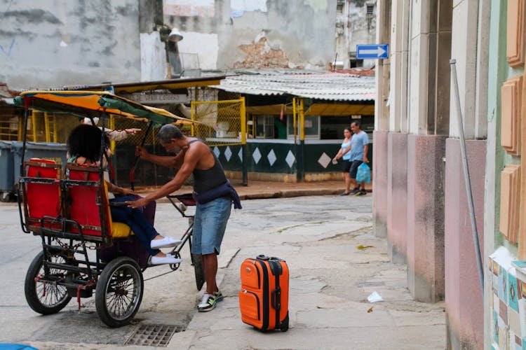 Driver Helping Woman Get Off The Rickshaw 