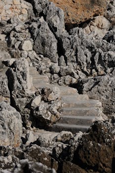 A rustic stone staircase blends seamlessly with rugged rocks in Provence-Alpes-Côte d'Azur, France.