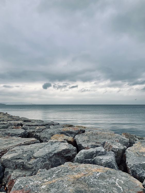 Gray Rocks near Ocean under the Sky · Free Stock Photo