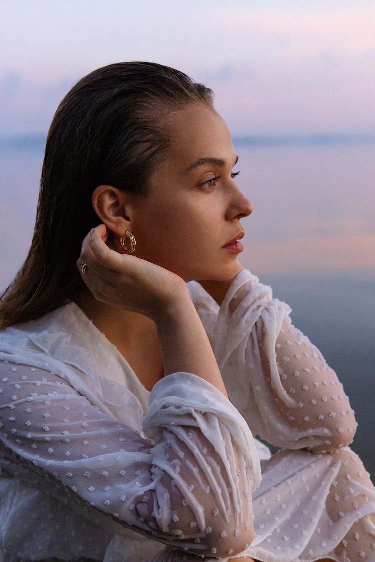 Side Portrait Of Woman Sitting By The Sea