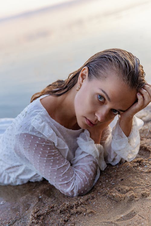 Free Woman with Wet Hair Lying on Front on Beach Stock Photo
