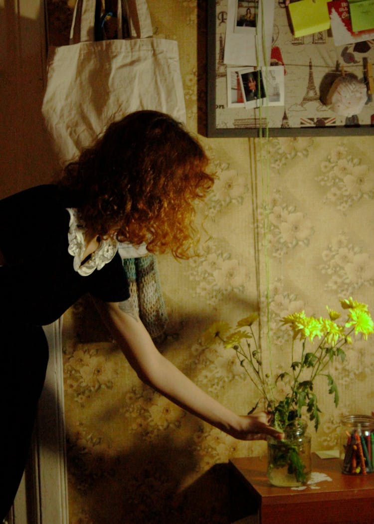 Person Putting Flowers With Vase On A Table