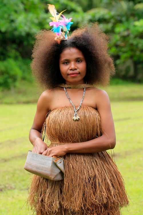Free Portrait of a woman in traditional Papuan attire with feathers and beads. Stock Photo