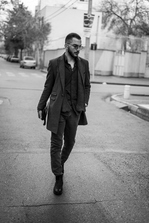 Free Monochrome shot of a man in stylish outerwear walking on a street, exuding fashion vibes. Stock Photo