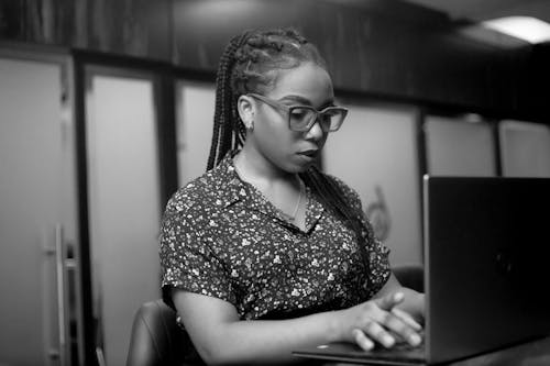 Black and White Photo of a Woman Using a Laptop