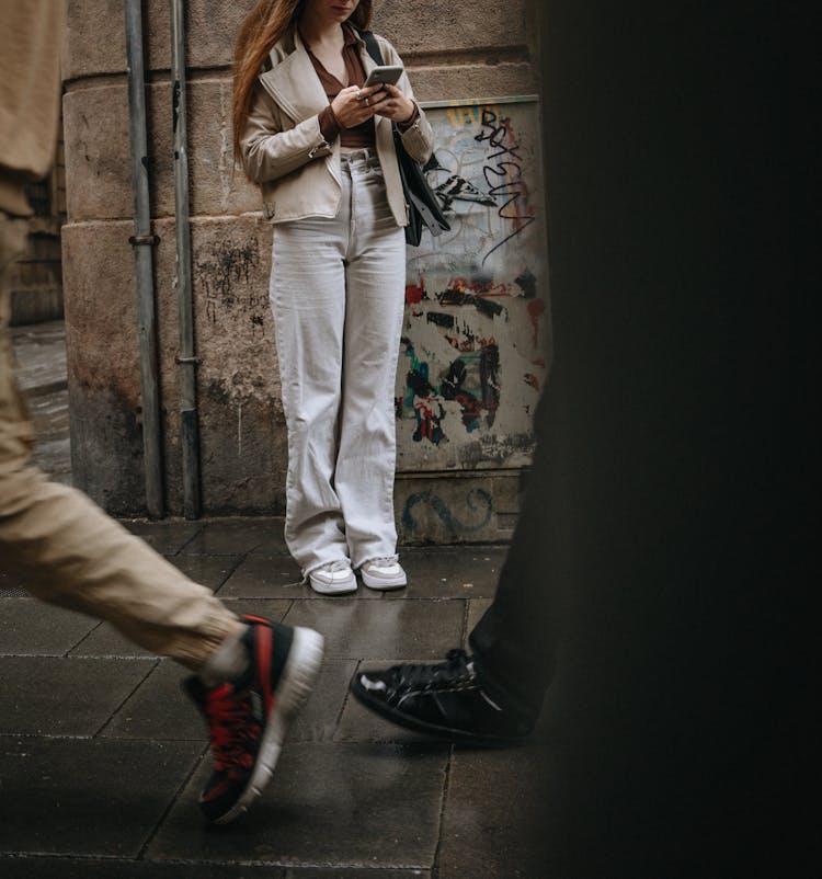 Woman Using Smartphone On Sidewalk