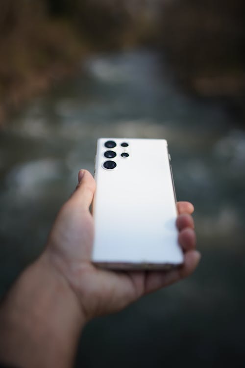 Close Up Photo of a Person Holding a White Cellphone