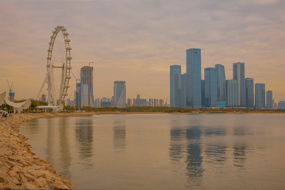 Captivating view of Shenzhen skyline and Ferris wheel reflected in the water during twilight.