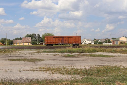 A Freight Train on Train Tracks Under a Cloudy Sky