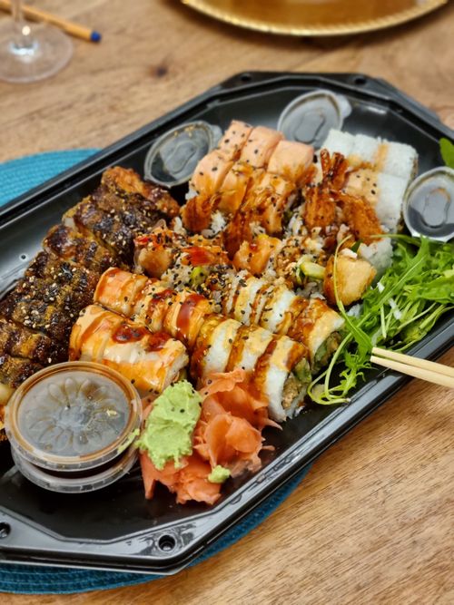 Free A tempting sushi platter with various rolls, garnishes, and sauces on a black tray. Stock Photo