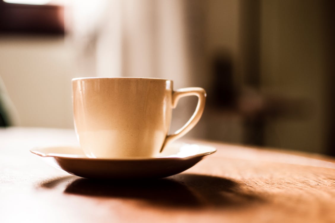 免费 白色陶瓷茶杯与茶碟木制的桌子上 素材图片