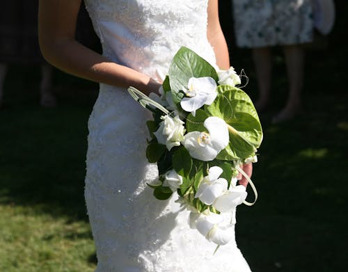 Close-Up Shot of a Woman in White Bridal Gown Holding a Wedding Bouquet