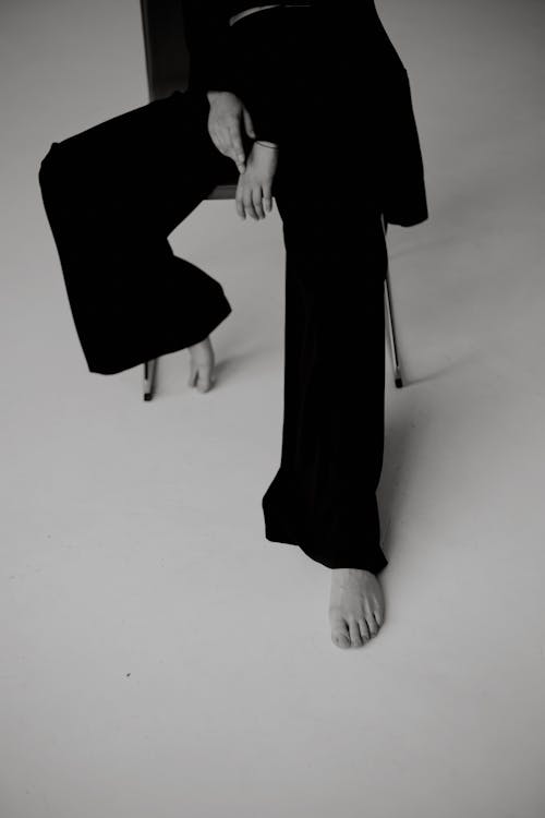 Woman Sitting Barefoot and in Black Outfit