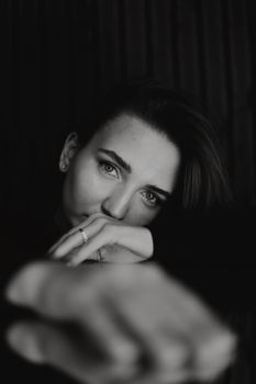 Dramatic black and white portrait of a woman with a contemplative expression.