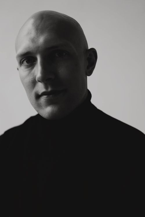 Free A dramatic close-up black-and-white portrait of a bald man in a turtleneck. Stock Photo