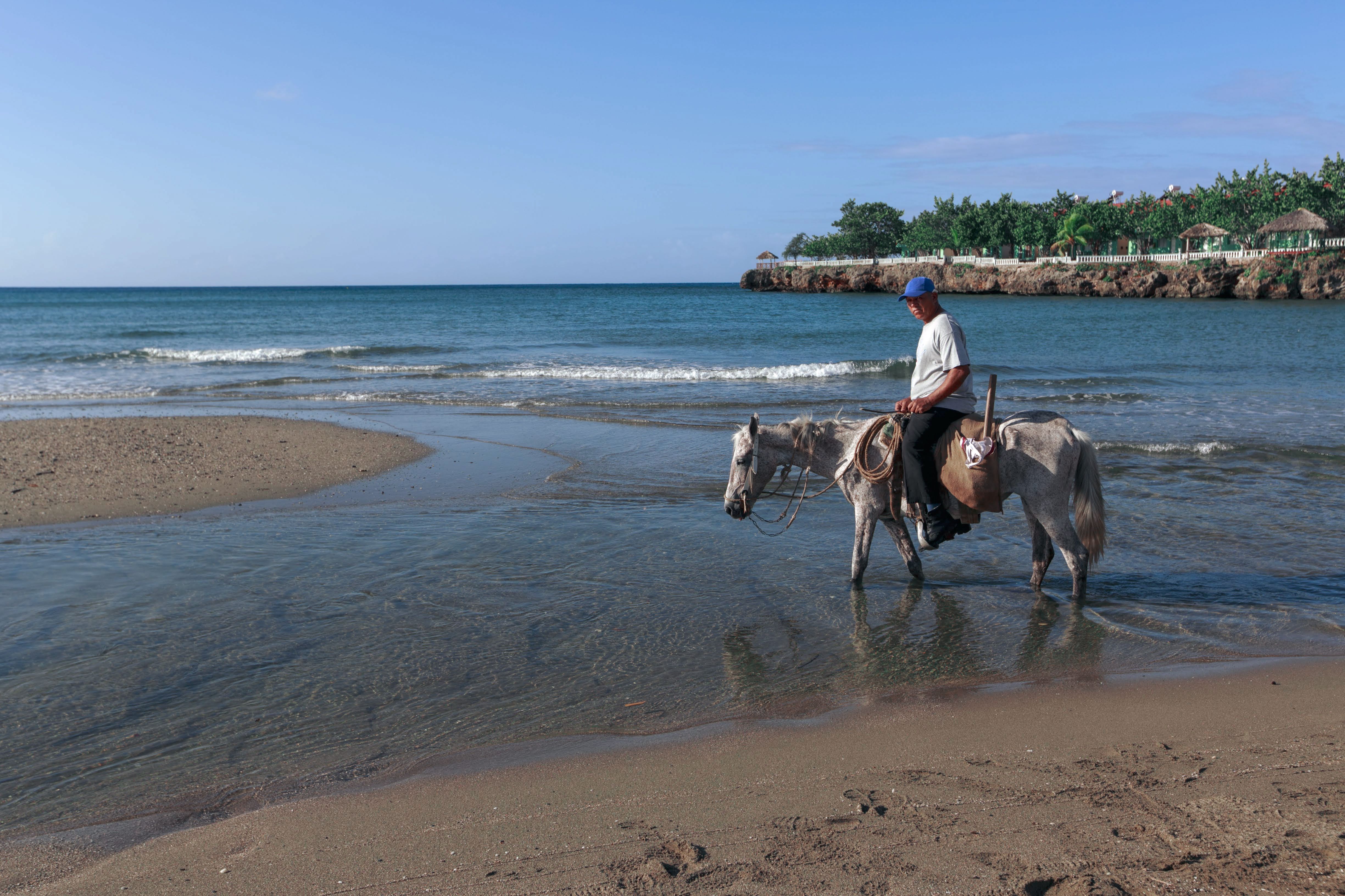 Man riding horse along the Caribbean coast