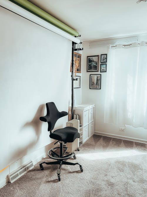 Free Black Office Rolling Chair Beside White Wall Stock Photo