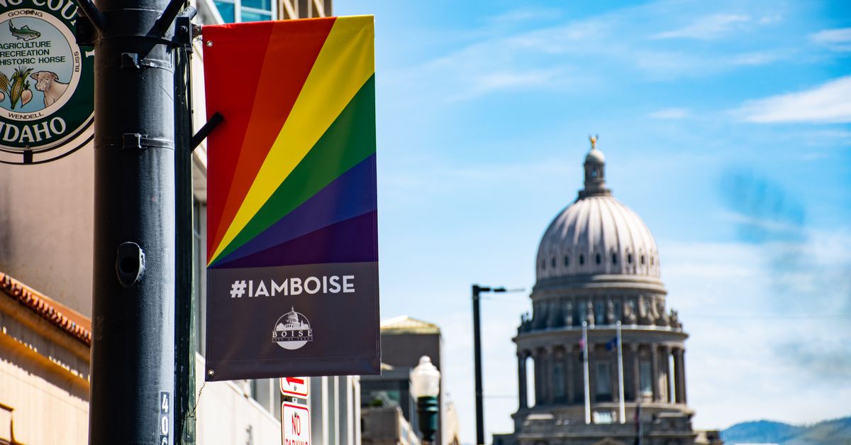 View of the Boise Capitol building with a rainbow pride banner in bright daylight.