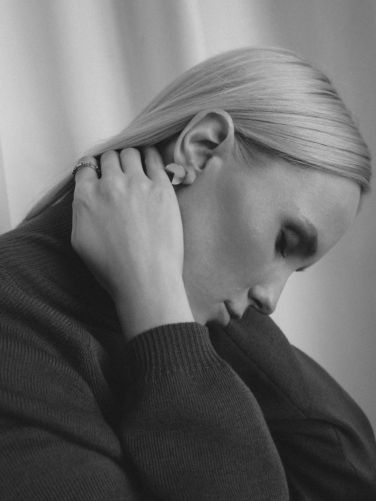 Woman With Head Down Touching Her Neck