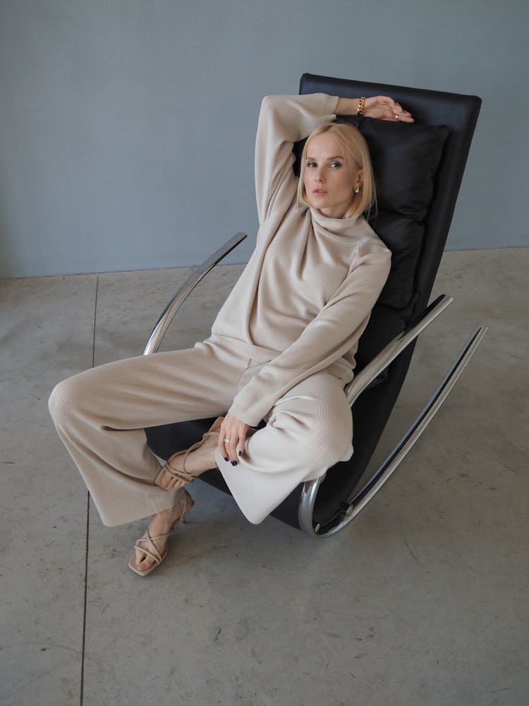 Woman In Whole Beige Outfit Sitting In Armchair