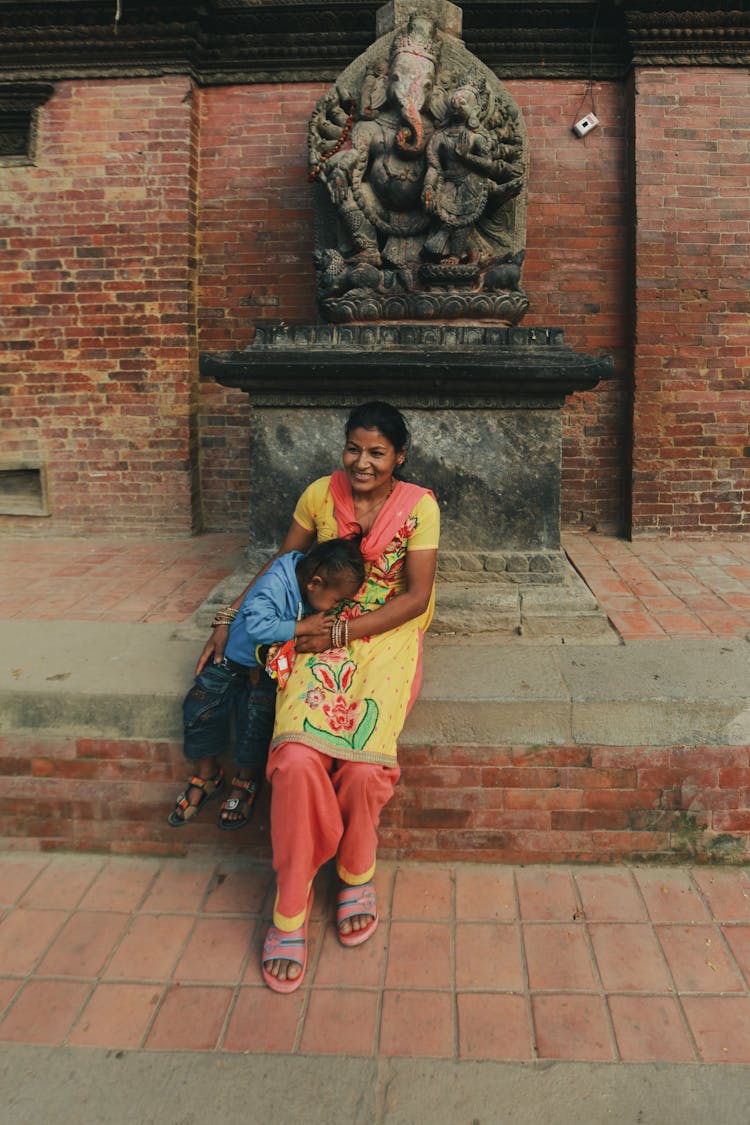 Smiling Young Woman With Child Near Statue