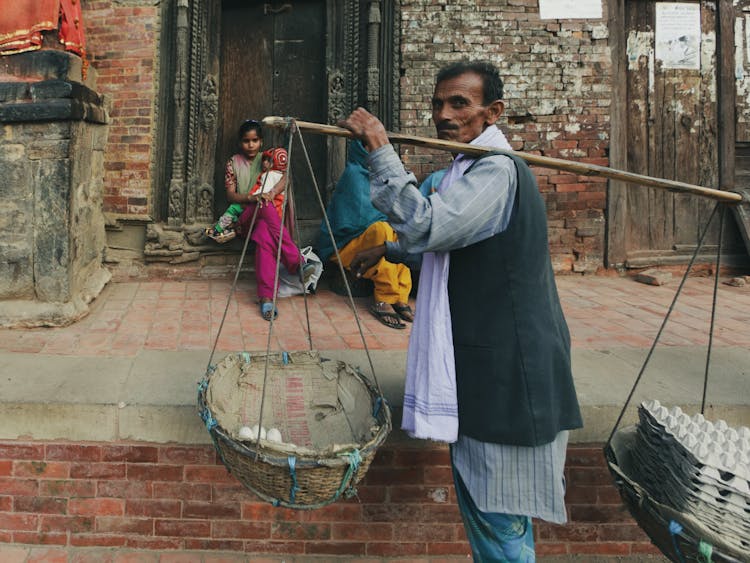 Old Man Carrying Load On Shoulder