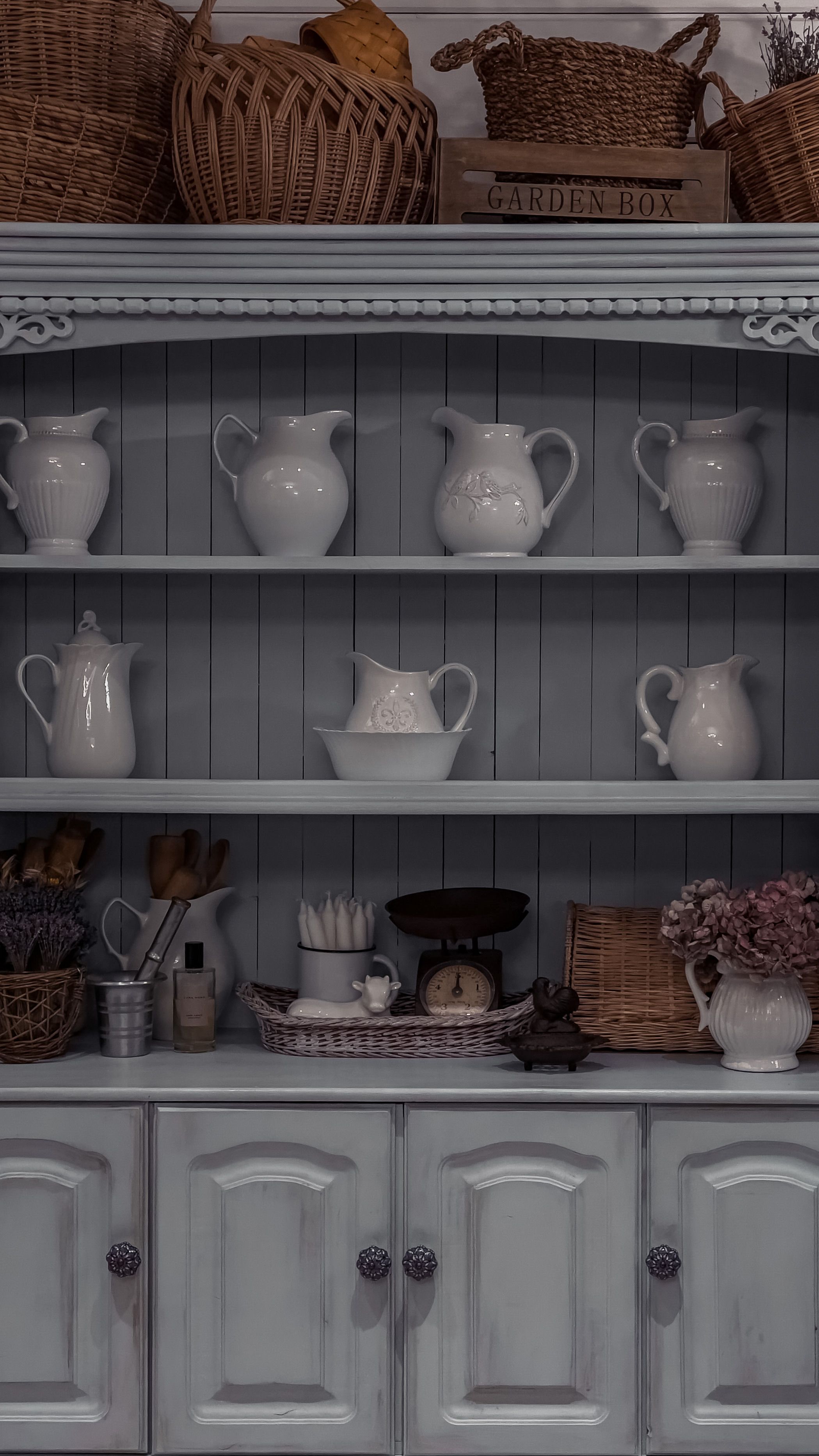 A farmhouse kitchen rustic coffee bar cabinet made from reclaimed wood with wrought iron mug hooks