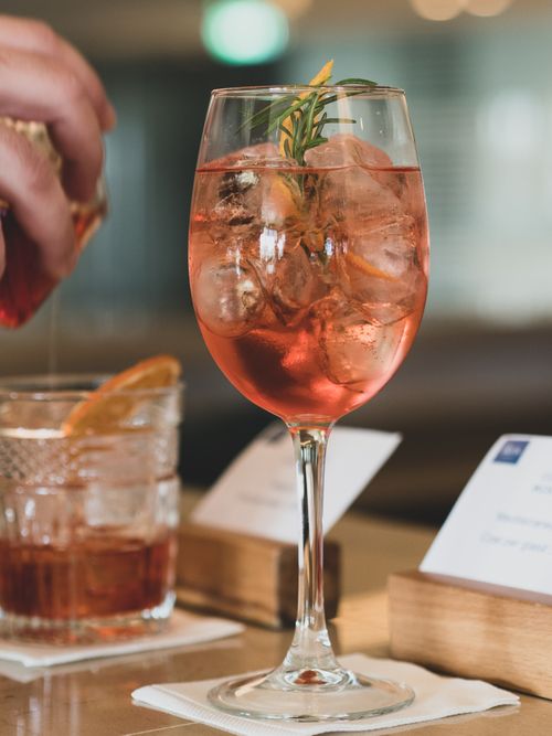 Free A close-up of a refreshing Aperol Spritz garnished with rosemary and citrus. Stock Photo