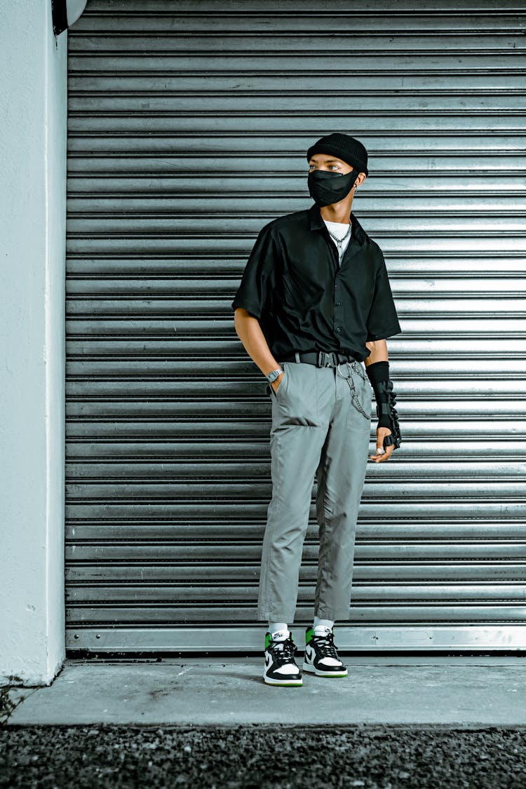 Man In Face Mask Standing Near Garage Doors