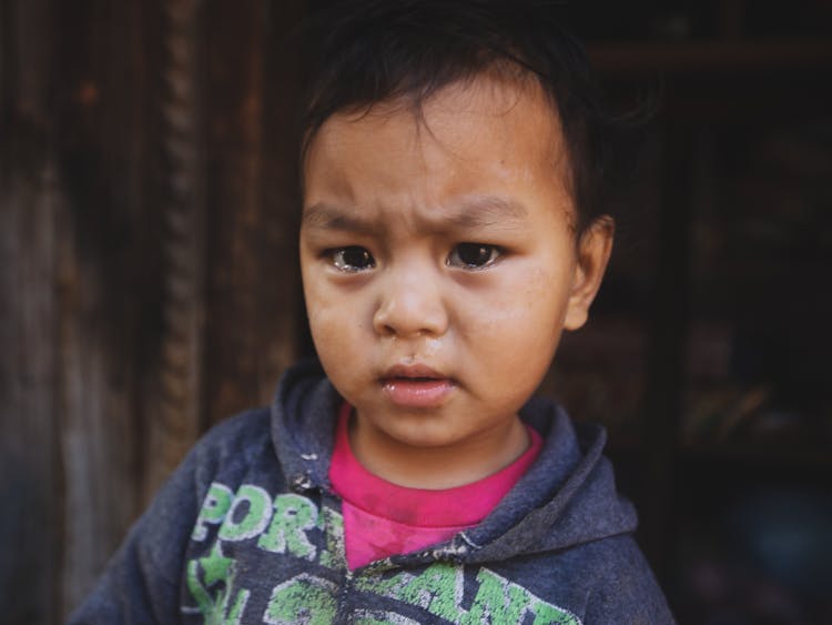 A Little Kid With Teary Eyed Looking At The Camera