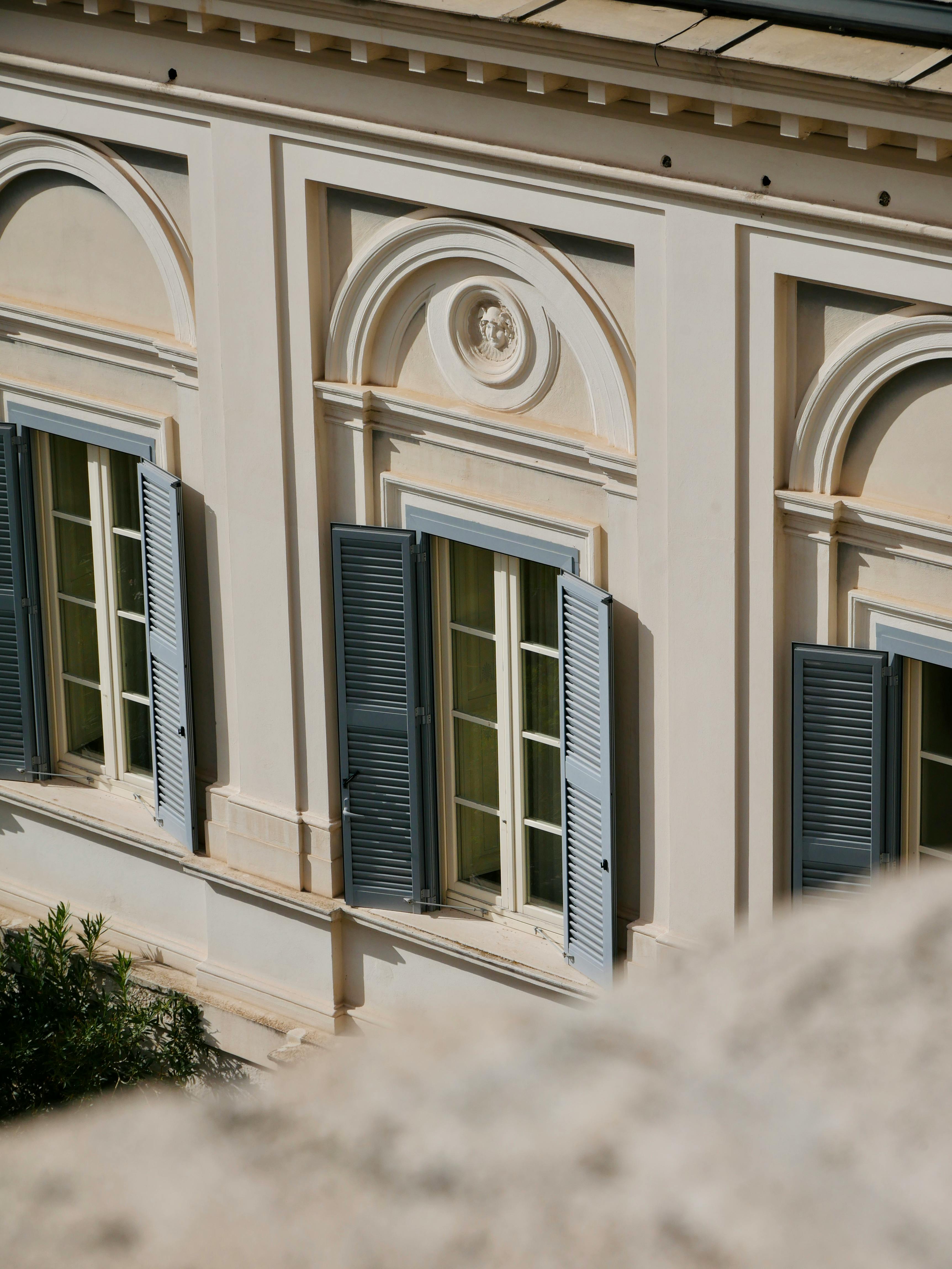 Elegant Renaissance-style building facade in Rome, Italy, showcasing intricate window designs.