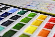 特写镜头中，色彩各异的调色板上充满活力的水彩画