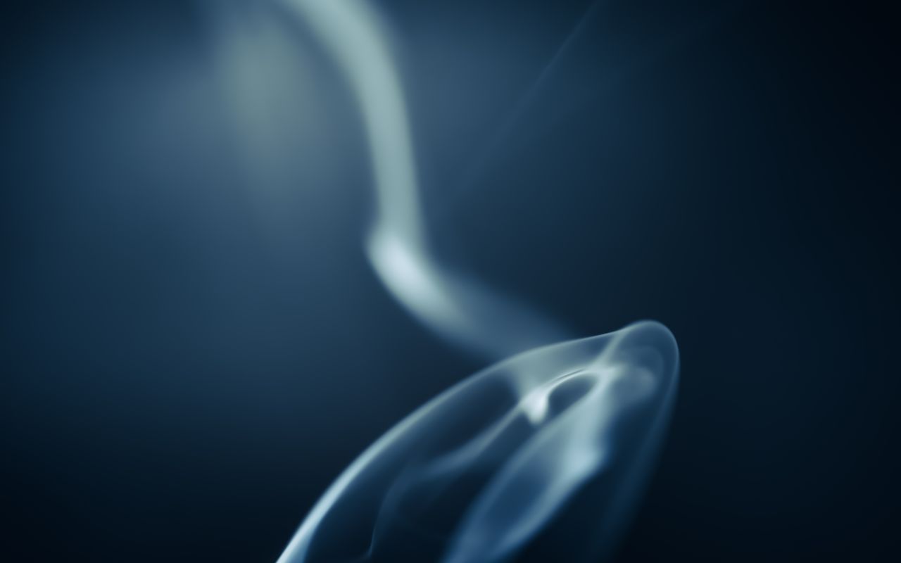 abstract close up of ethereal smoke swirl on a blue background creatin