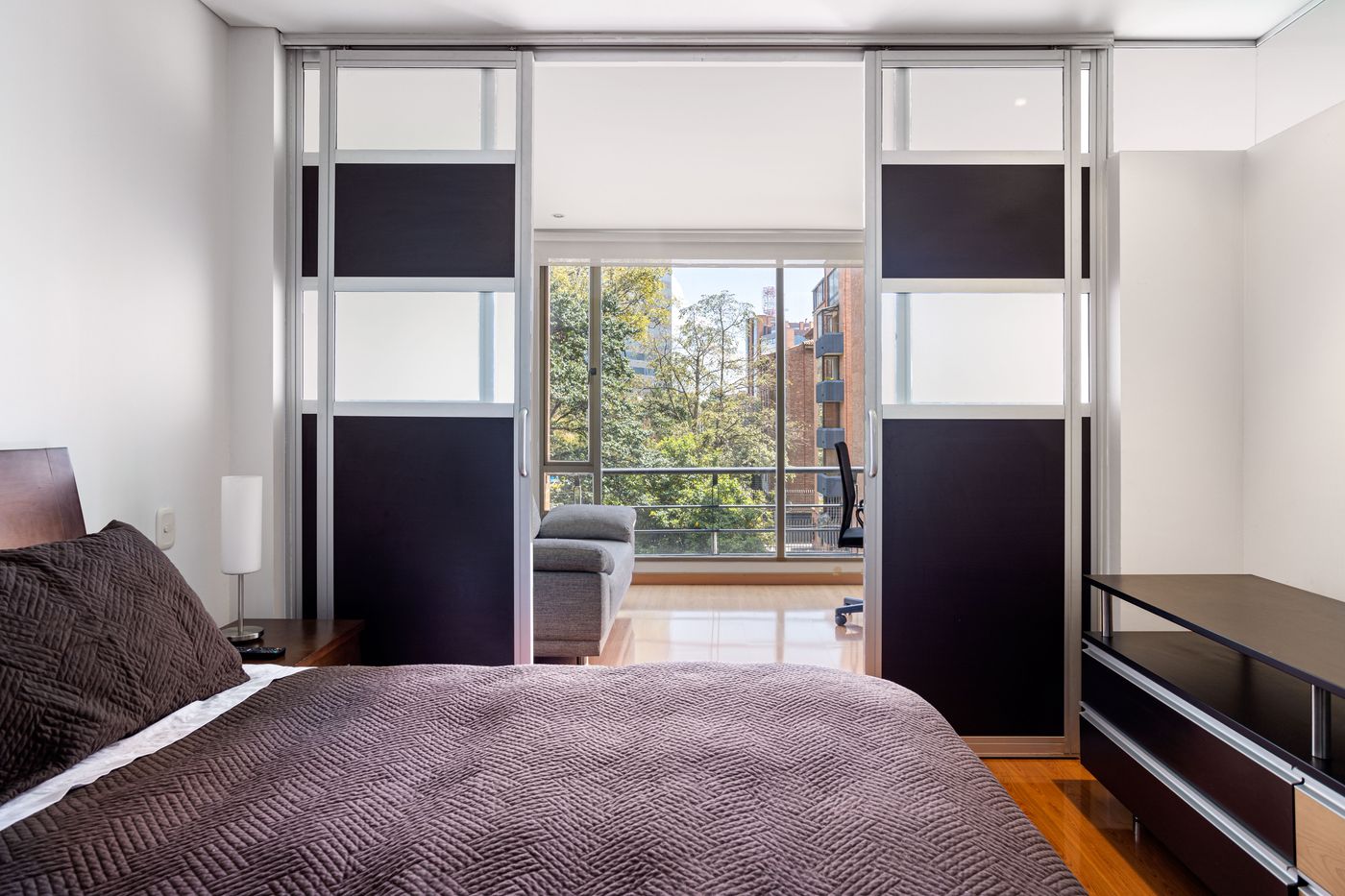 Bright bedroom with large glazed doors and windows