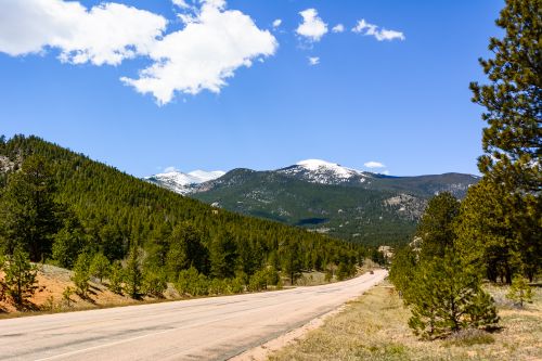 Free Breathtaking view of snow-capped mountains and coniferous forest from a road in Estes Park, Colorado. Stock Photo